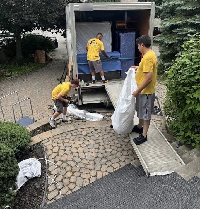 Des déménageurs de Logistiques CNS chargent un camion à la deuxième adresse