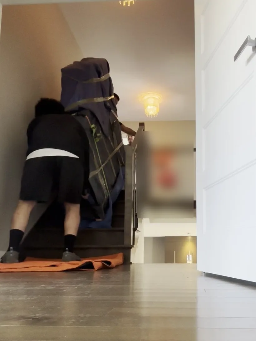 Dans le deuxième escalier, un déménageur retient le piano par le bas